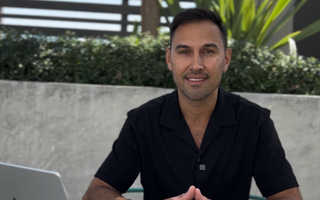 Victor Salazar seated at an outdoor table with a laptop, mortgage broker near me at Kings of Lending