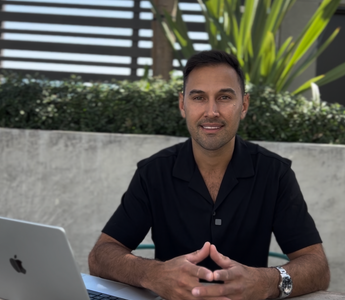 Victor Salazar seated at an outdoor table with a laptop, mortgage broker near me at Kings of Lending